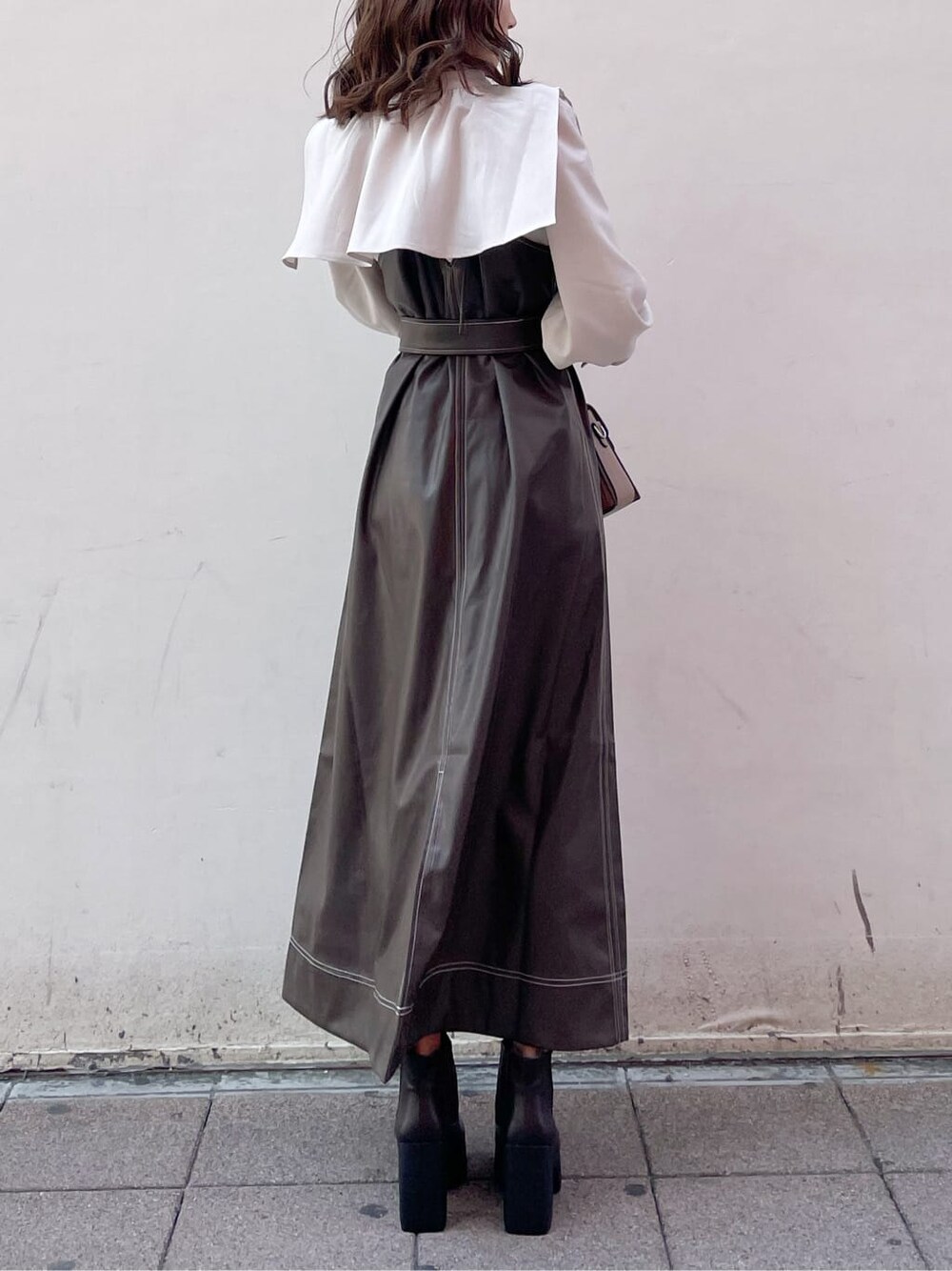 ブラウン系のワンピース、ブラウン系のブーツ、ベージュ系のシャツ/ブラウスを着用したレディースの冬コーディネートの2枚目の写真