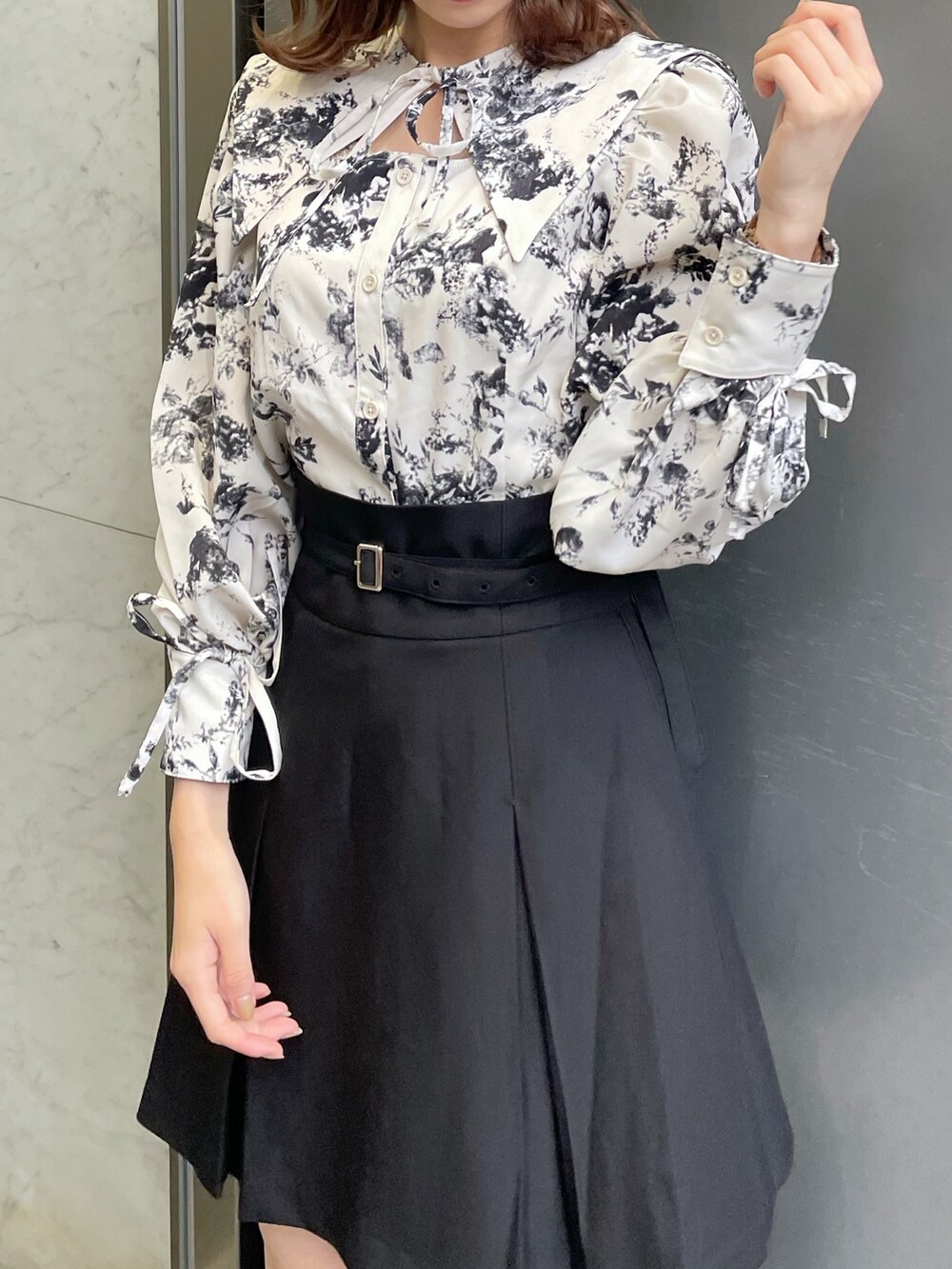 ホワイト系のシャツ/ブラウス、ブラック系のスカート、ブラック系のブーツを着用したレディースの冬コーディネートの6枚目の写真