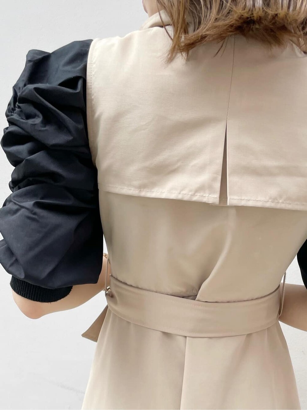 ベージュ系のワンピース、ブラック系のハンドバッグ、ブラック系のニット/セーターを着用したレディースの秋コーディネートの5枚目の写真