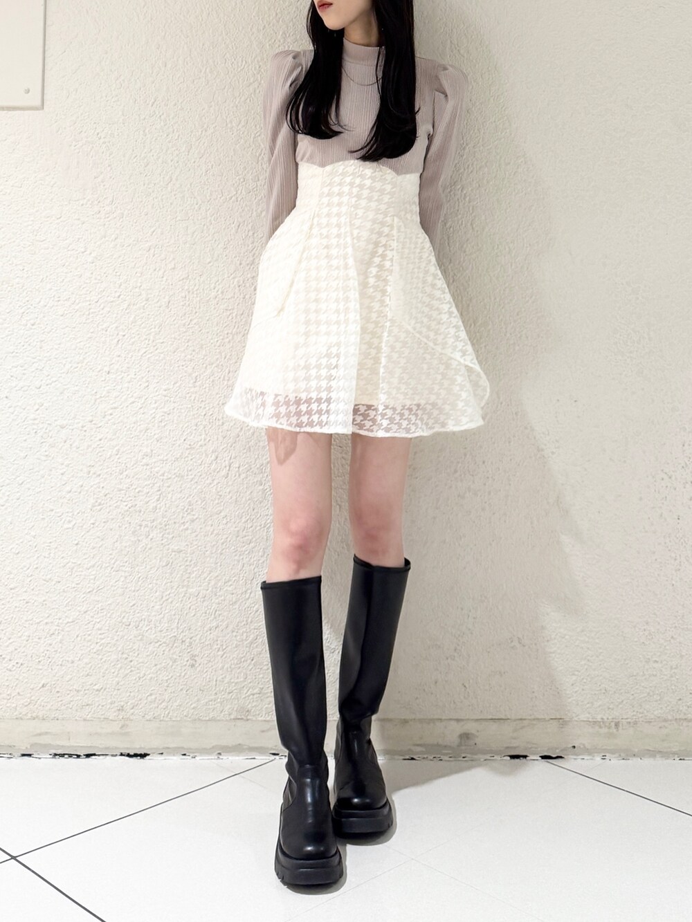 ベージュ系のワンピース、ブラック系のブーツを着用したレディースの春コーディネートの3枚目の写真