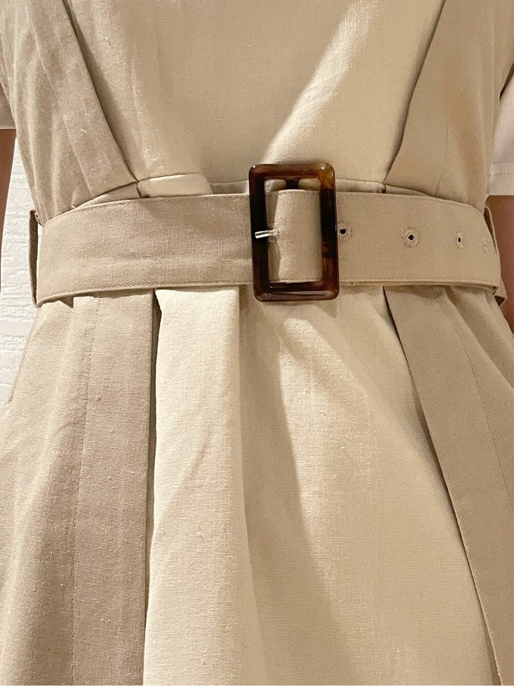 ホワイト系のスニーカー、ベージュ系のワンピース、ホワイト系のTシャツ/カットソーを着用したレディースの春コーディネートの7枚目の写真