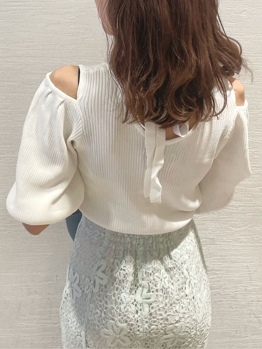 ホワイト系のニット/セーター、ブルー系のスカート、ブルー系のハンドバッグを着用したレディースの春コーディネートの5枚目の写真