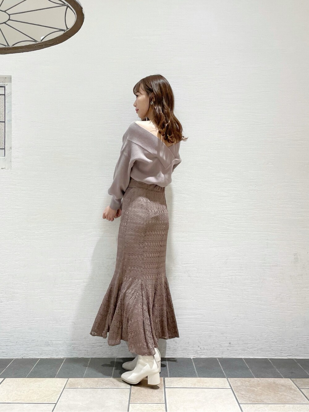 ホワイト系のブーツ、ベージュ系のスカート、パープル系のニット/セーターを着用したレディースの冬コーディネートの3枚目の写真