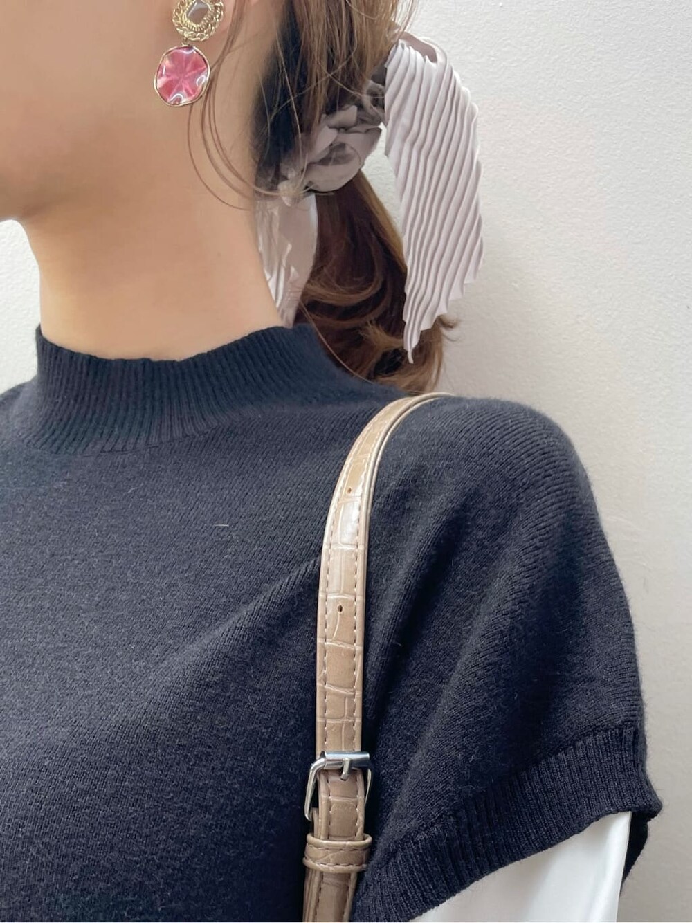 ブラック系のブーツ、ブラック系のワンピース、ベージュ系のハンドバッグを着用したレディースの秋コーディネートの8枚目の写真