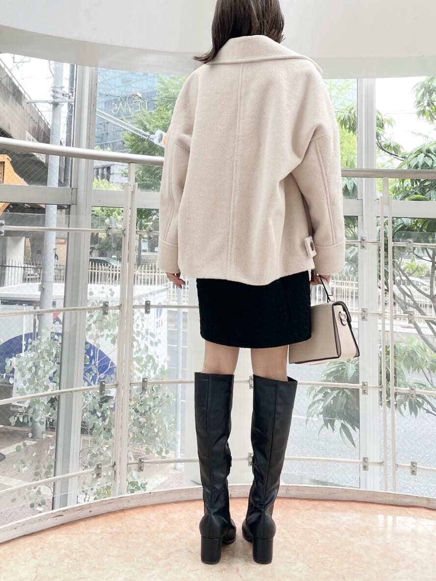 ブラック系のチュニック、ホワイト系のその他アウター、ブラック系のブーツを着用したレディースの夏コーディネートの3枚目の写真