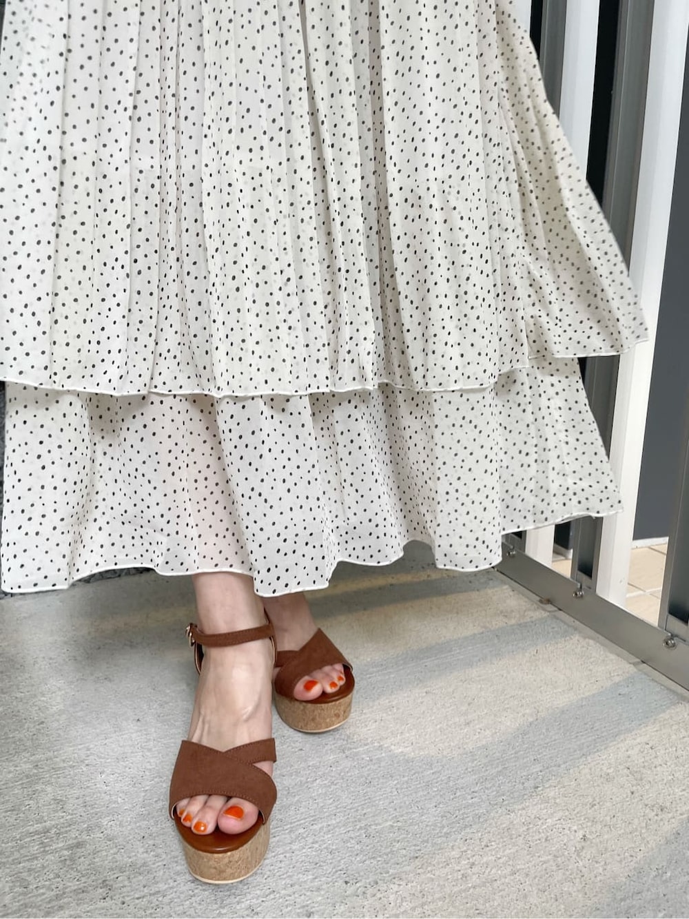 ブラウン系のサンダル、ブラウン系のハンドバッグ、ホワイト系のスカートを着用したレディースの夏コーディネートの10枚目の写真