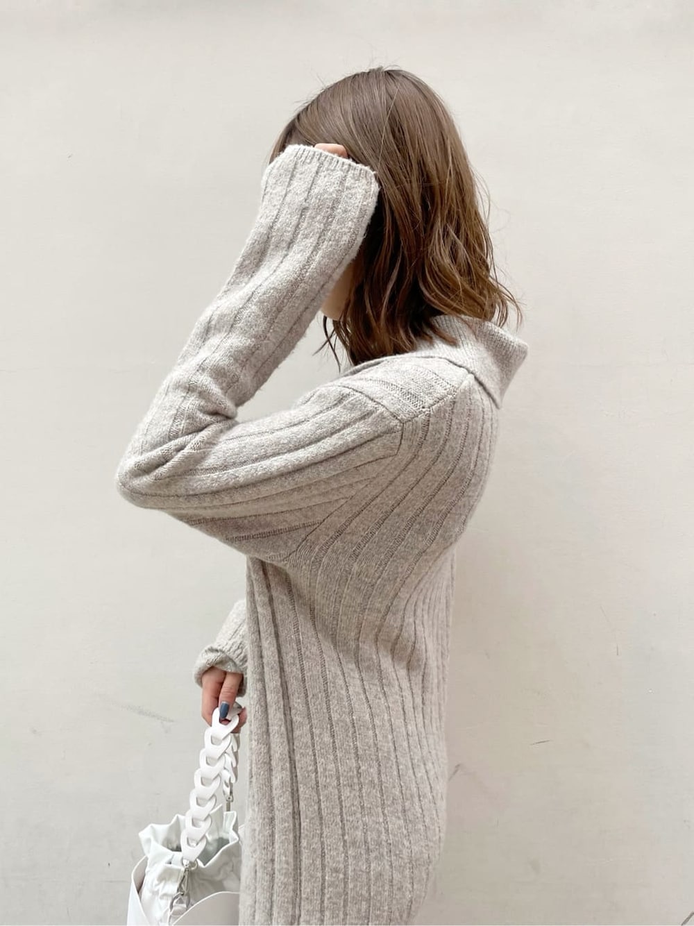 グレー系のワンピース、ホワイト系のハンドバッグ、ベージュ系のブーツを着用したレディースの秋コーディネートの6枚目の写真