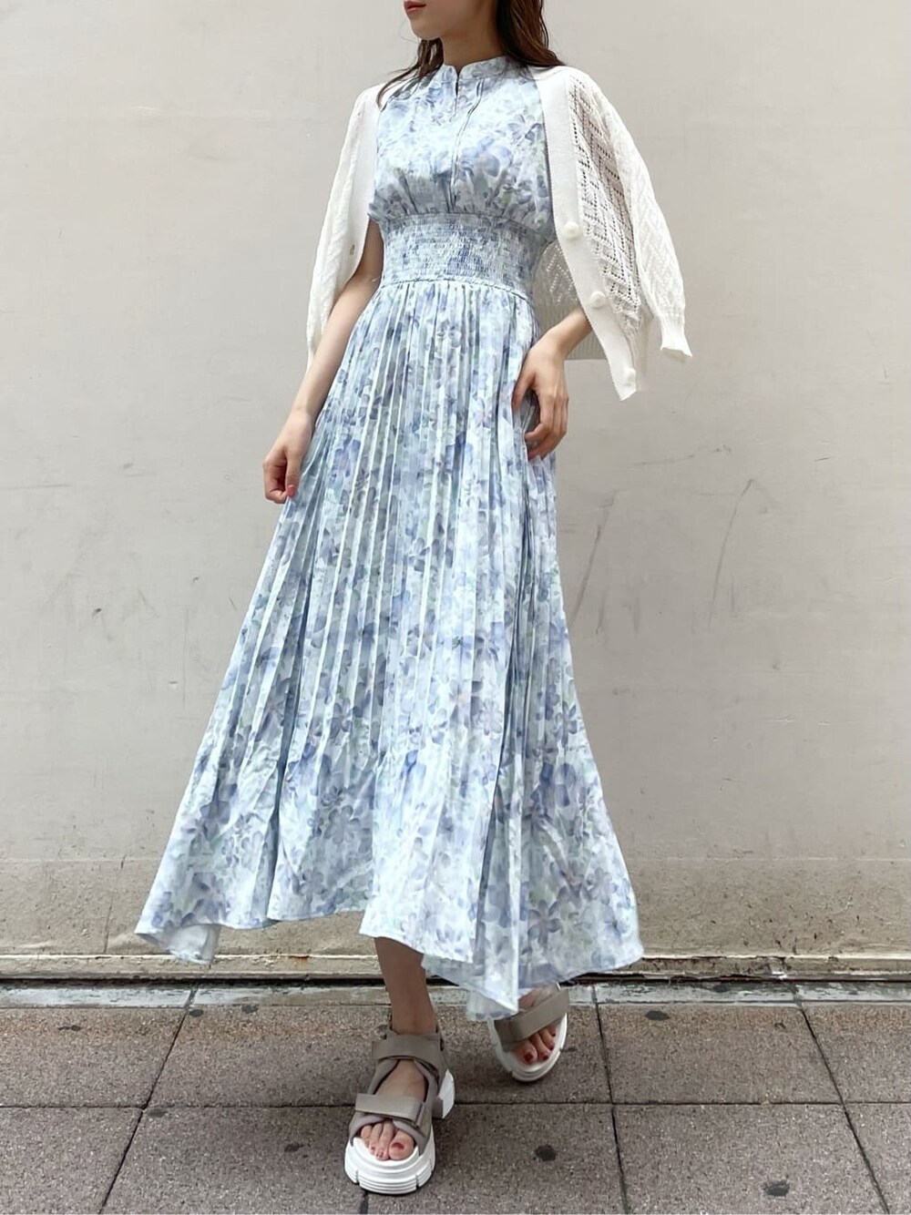 ホワイト系のカーディガン/ボレロ、ブルー系のワンピース、ベージュ系のサンダルを着用したレディースの夏コーディネートの2枚目の写真