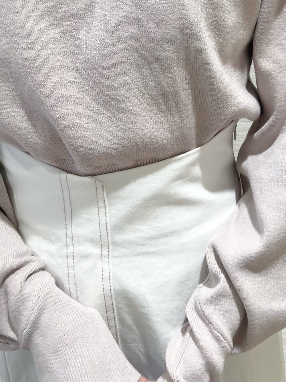 ベージュ系のニット/セーター、ブルー系のハンドバッグ、ベージュ系のブーツを着用したレディースの冬コーディネートの7枚目の写真