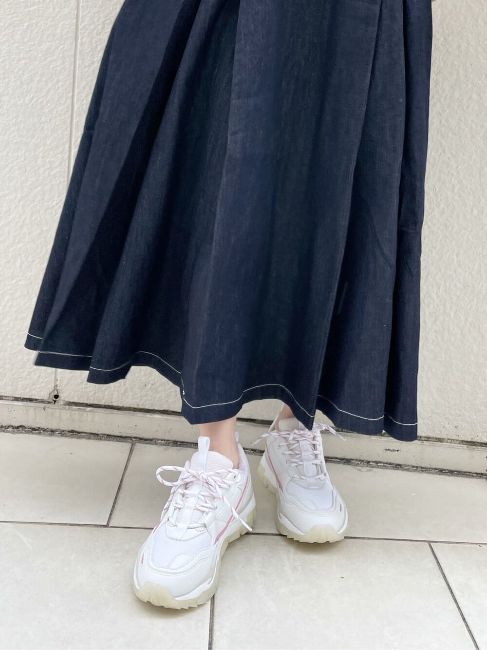 ピンク系のスニーカー、ブルー系のワンピース、ベージュ系のカーディガン/ボレロを着用したレディースの冬コーディネートの9枚目の写真