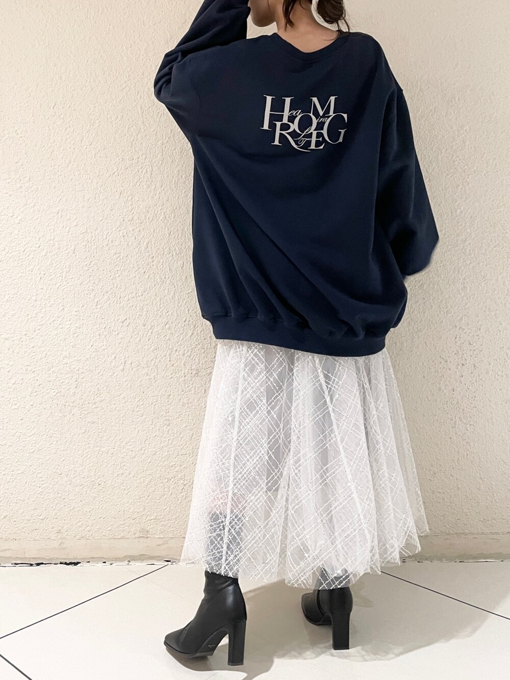 グレー系のスカート、ブラック系のブーツ、ブルー系のTシャツ/カットソーを着用したレディースの冬コーディネートの3枚目の写真