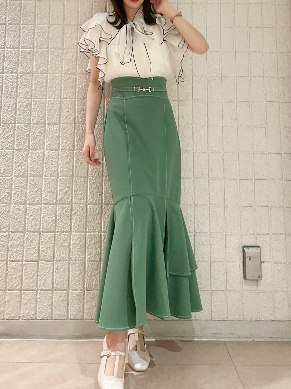 ホワイト系のシャツ/ブラウス、グリーン系のスカート、ホワイト系のパンプスを着用したレディースの春コーディネートの4枚目の写真