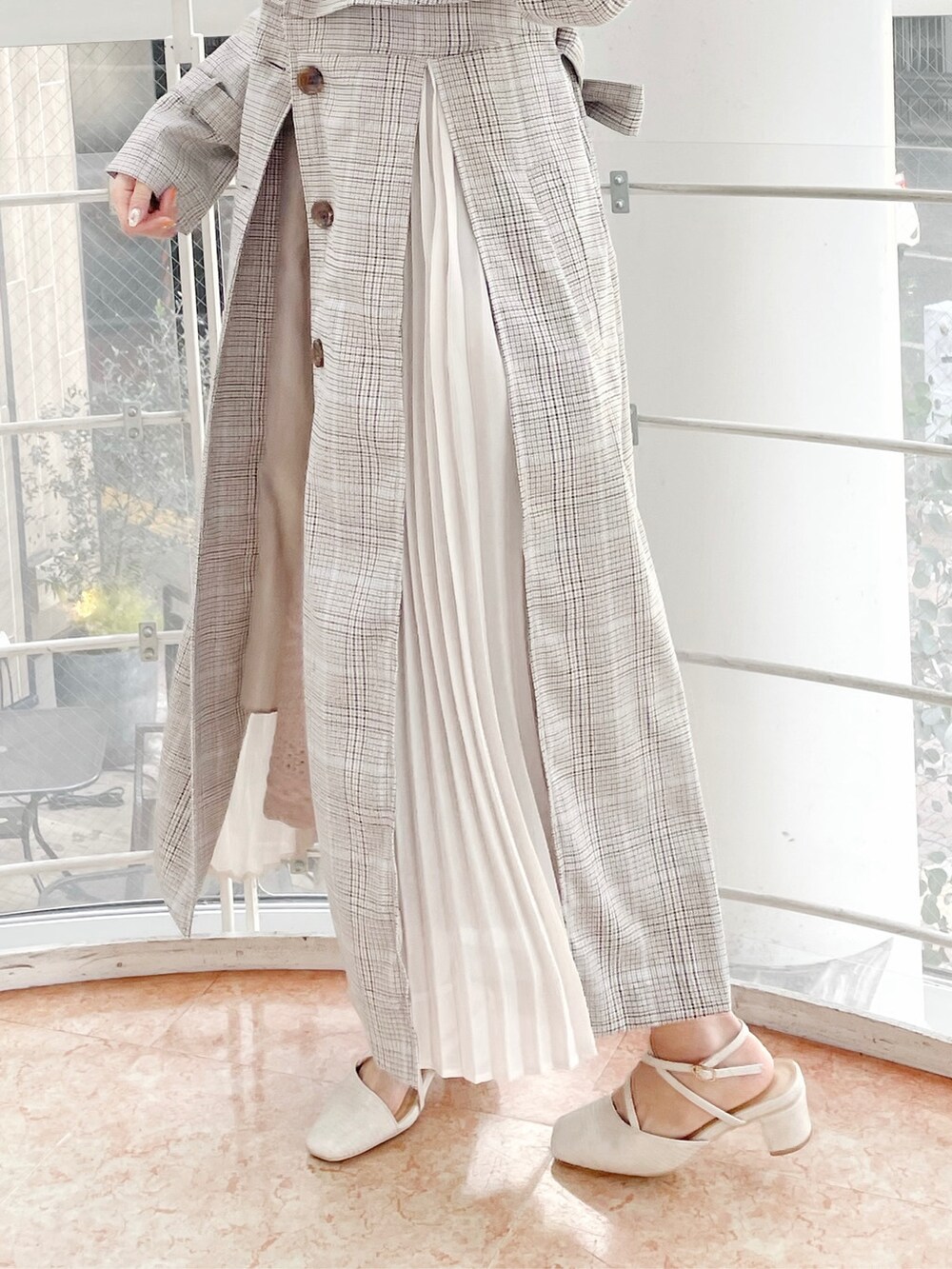 その他のトレンチコート、ベージュ系のスカート、ホワイト系のパンプスを着用したレディースの冬コーディネートの8枚目の写真