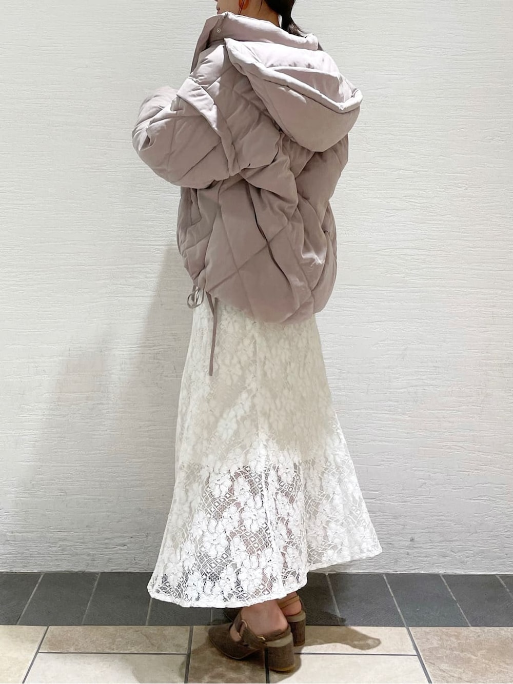 ホワイト系のスカート、ピンク系のダウンジャケット/コート、ブラウン系のニット/セーターを着用したレディースの夏コーディネートの2枚目の写真