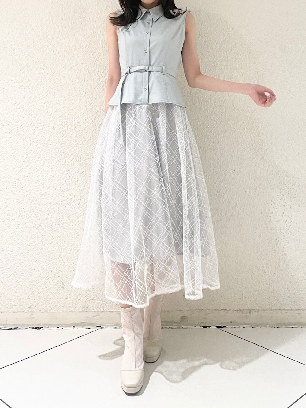 ブルー系のワンピース、ホワイト系のブーツを着用したレディースの冬コーディネートの2枚目の写真