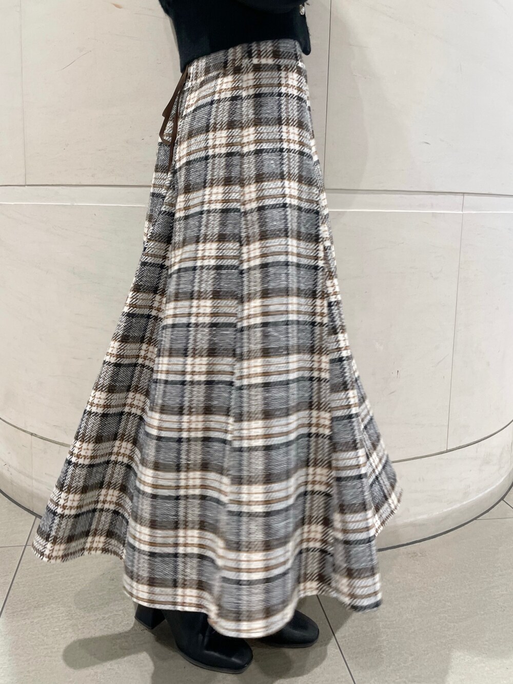 その他のスカート、ブラック系のニット/セーター、ブラック系のブーツを着用したレディースの冬コーディネートの7枚目の写真