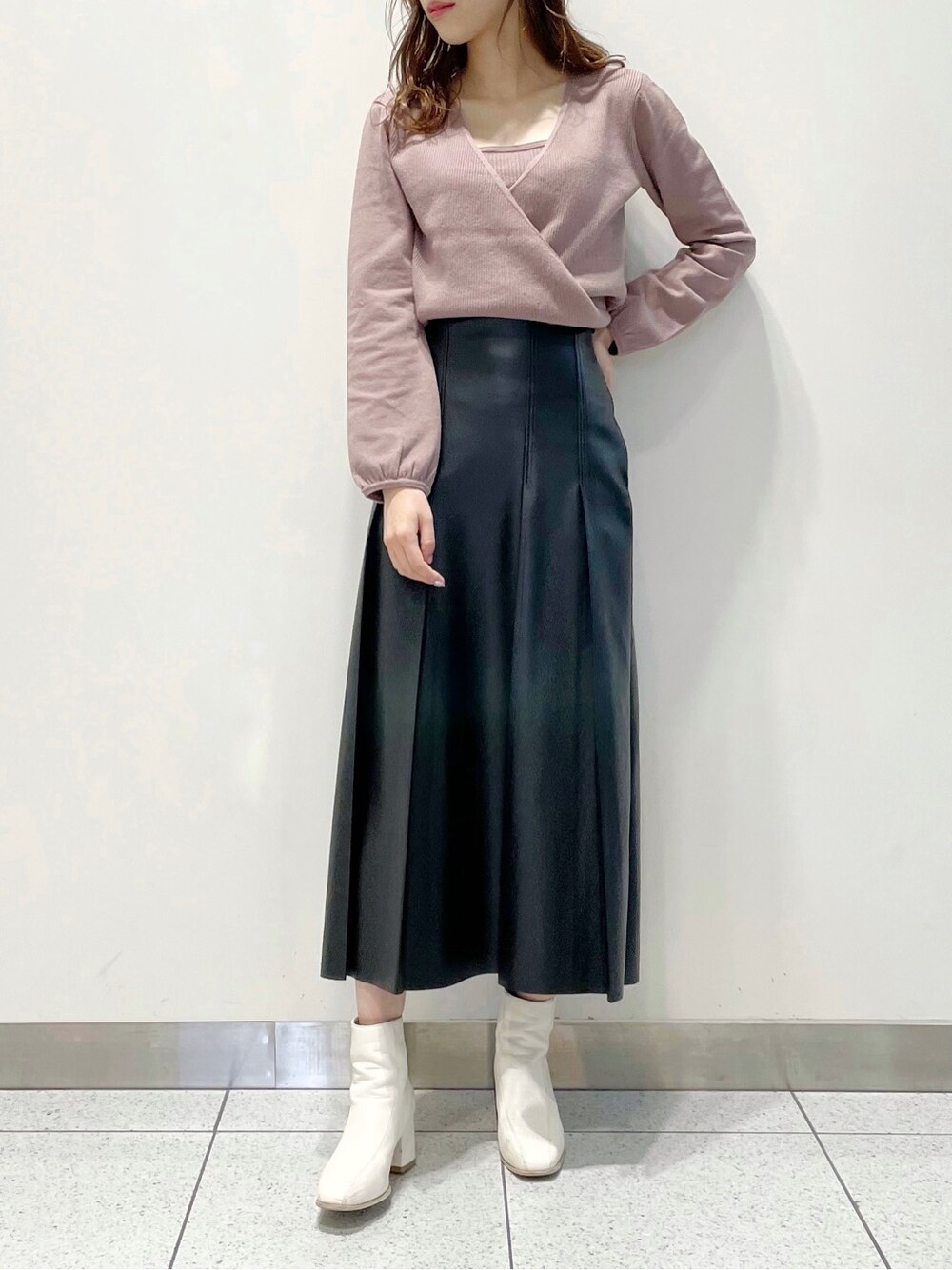 ホワイト系のブーツ、ブラック系のスカート、パープル系のニット/セーターを着用したレディースの冬コーディネートの2枚目の写真