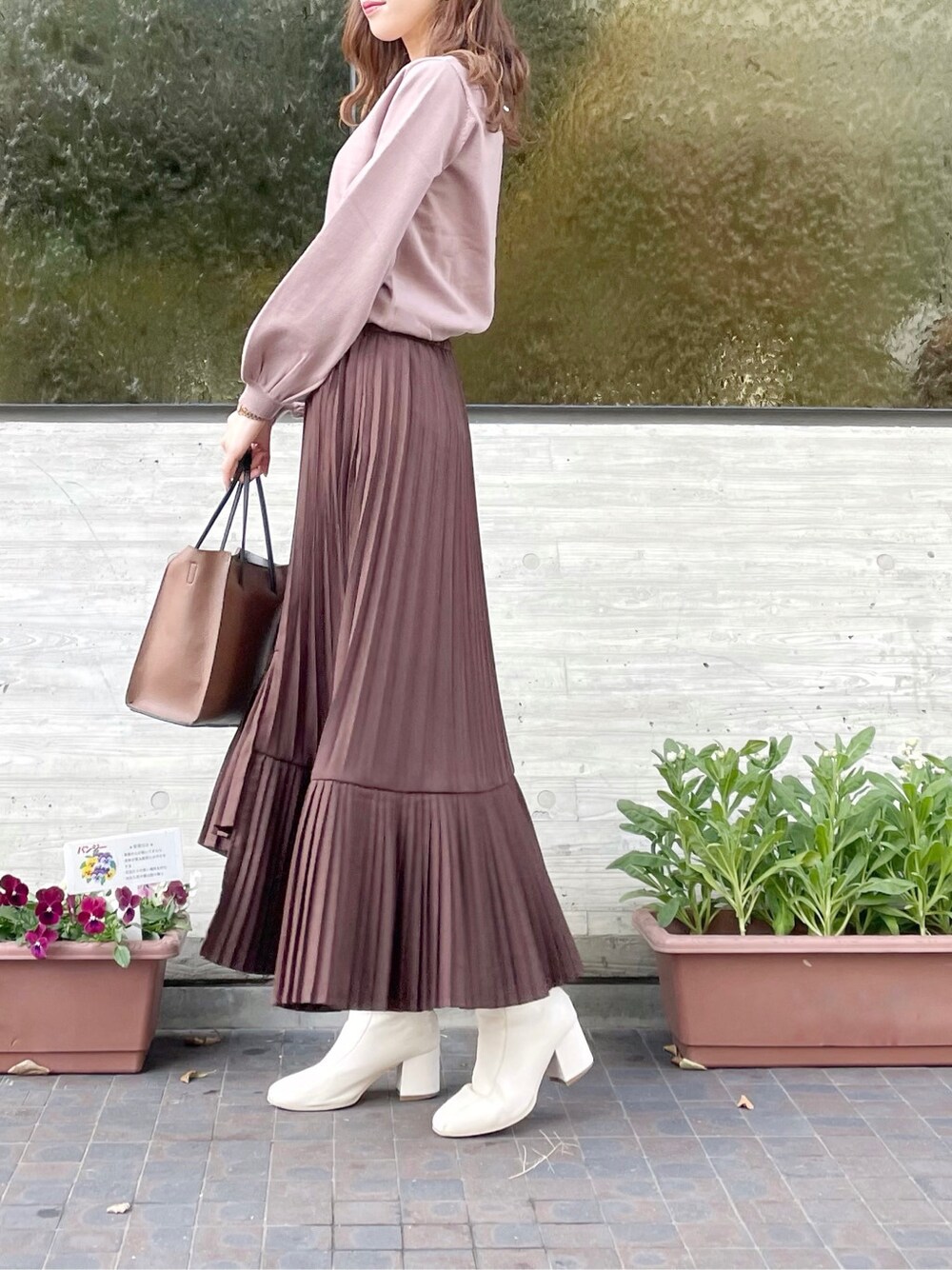 ホワイト系のブーツ、ブラウン系のハンドバッグ、パープル系のニット/セーターを着用したレディースの冬コーディネートの3枚目の写真