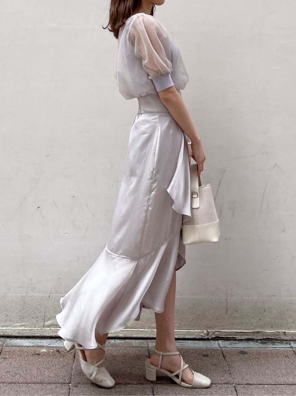 パープル系のニット/セーター、グレー系のスカート、ホワイト系のパンプスを着用したレディースの春コーディネートの4枚目の写真