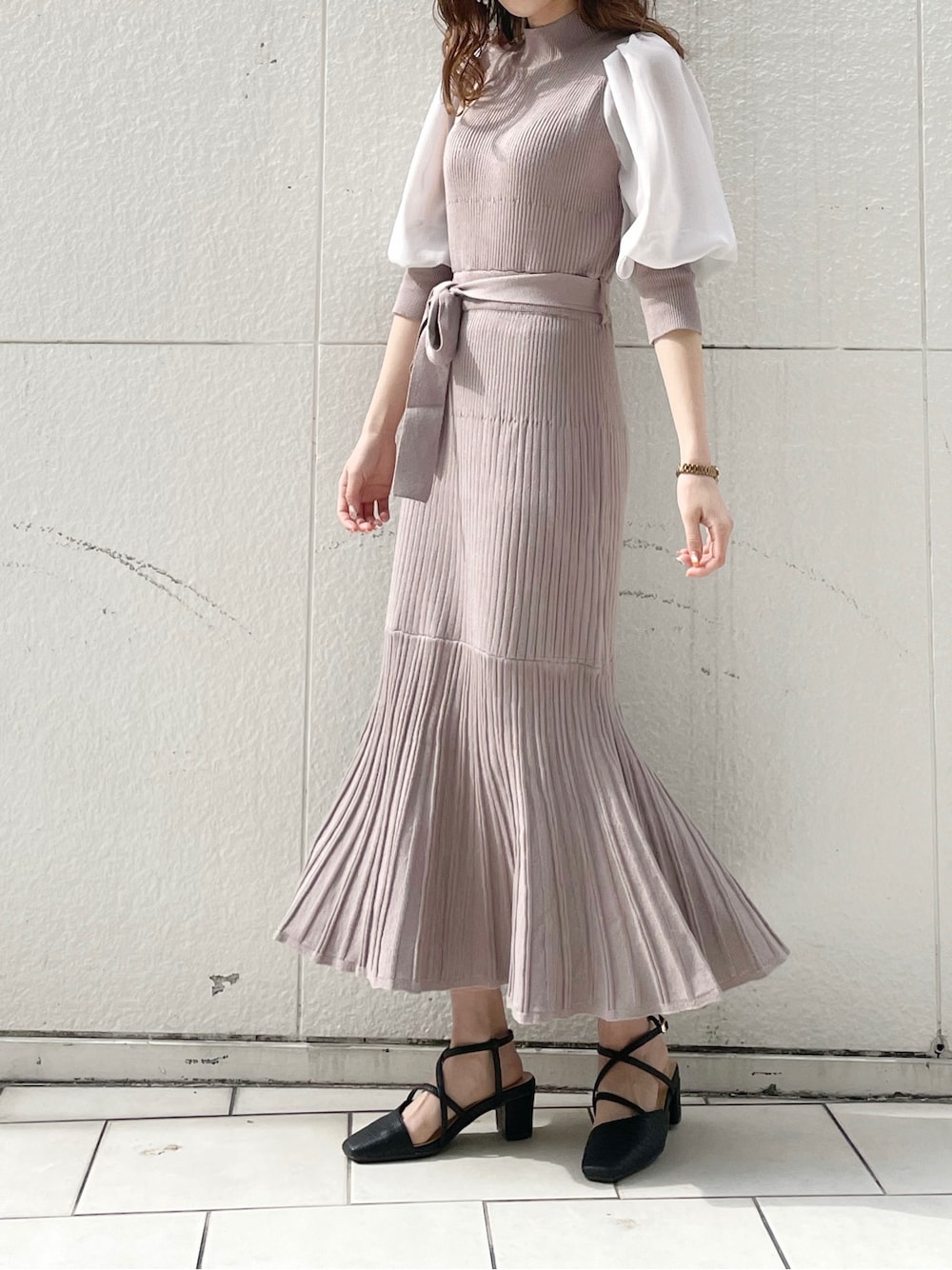 ベージュ系のワンピース、ブラック系のライダースジャケット、ブラック系のパンプスを着用したレディースの冬コーディネートの2枚目の写真