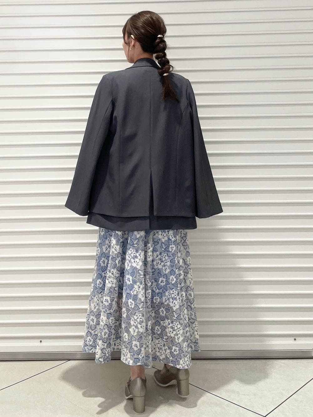 ブルー系のワンピース、シルバー系のパンプス、グレー系のテーラードジャケットを着用したレディースの冬コーディネートの4枚目の写真