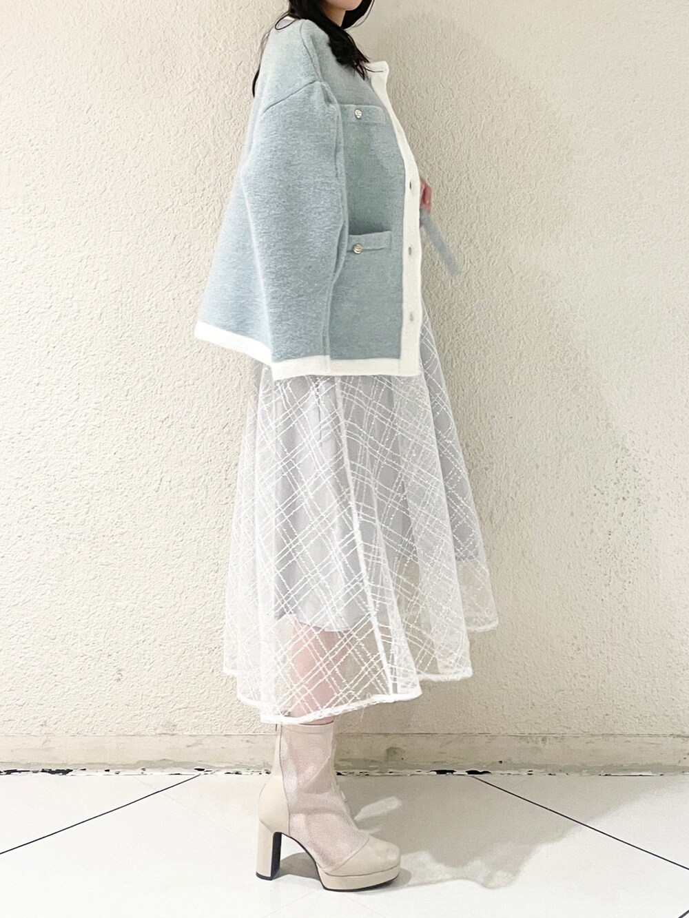 ブルー系のワンピース、ホワイト系のブーツを着用したレディースの冬コーディネートの3枚目の写真