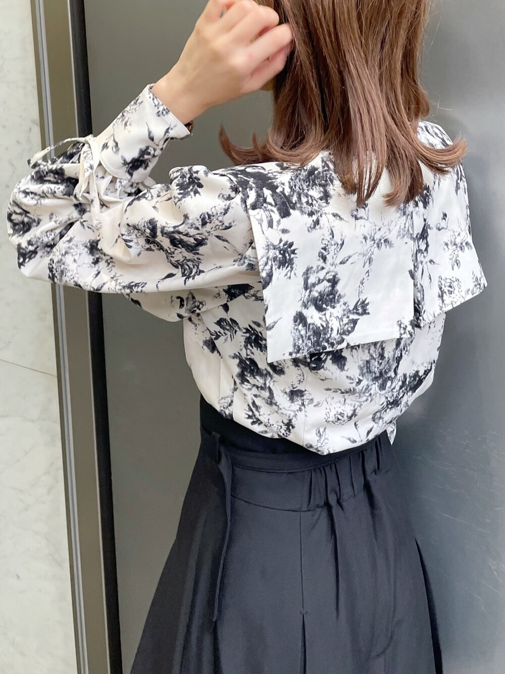 ホワイト系のシャツ/ブラウス、ブラック系のスカート、ブラック系のブーツを着用したレディースの冬コーディネートの5枚目の写真