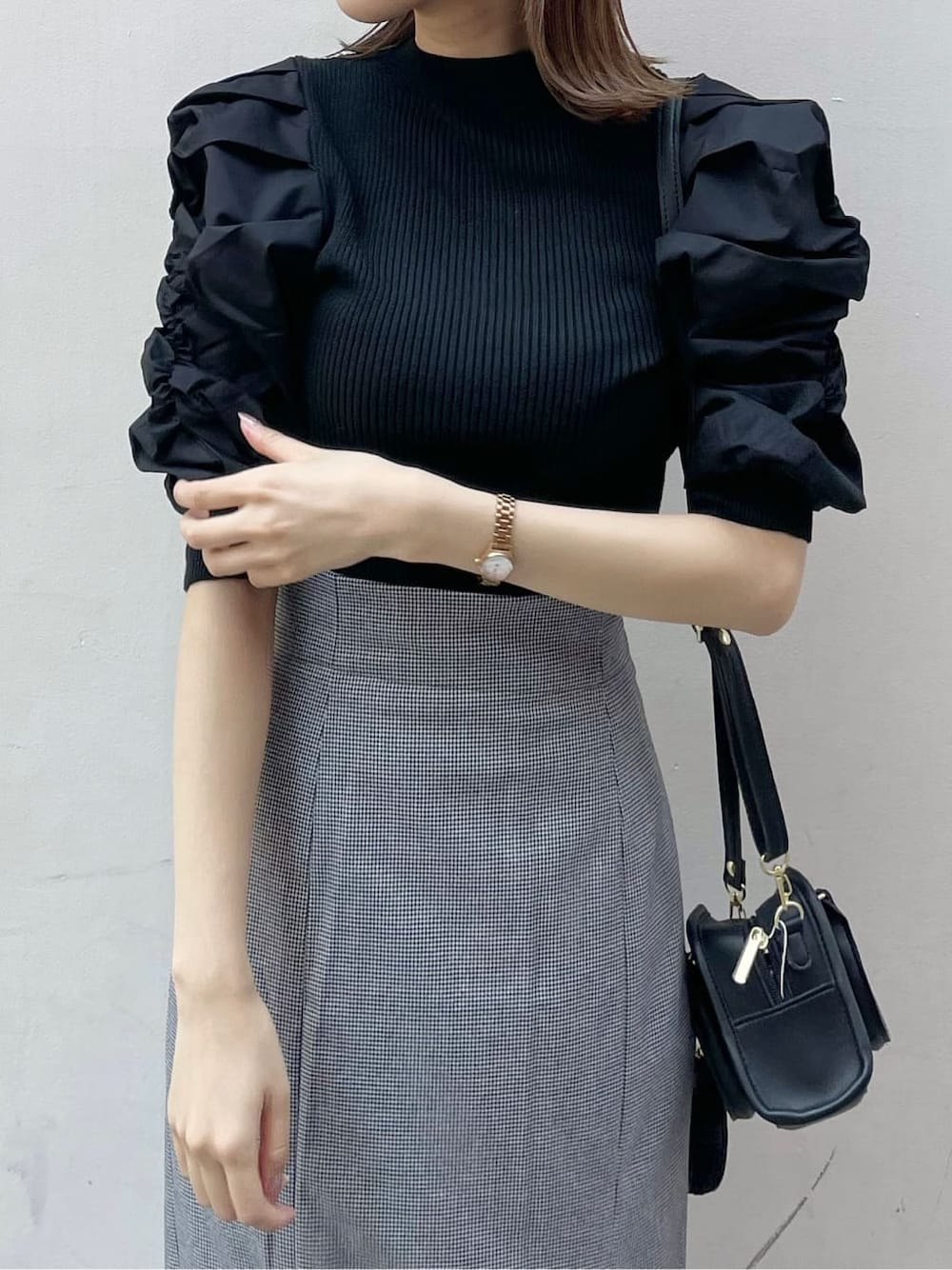 ブラック系のスカート、ブラック系のニット/セーター、ブラック系のハンドバッグを着用したレディースの秋コーディネートの5枚目の写真