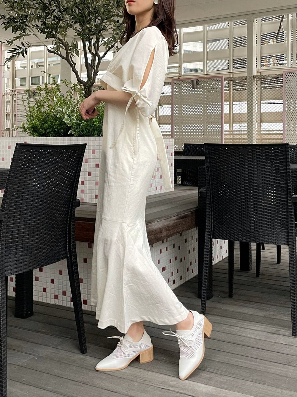 ベージュ系のデニムジャケット、ホワイト系のワンピース、ホワイト系のローファーを着用したレディースの春コーディネートの4枚目の写真