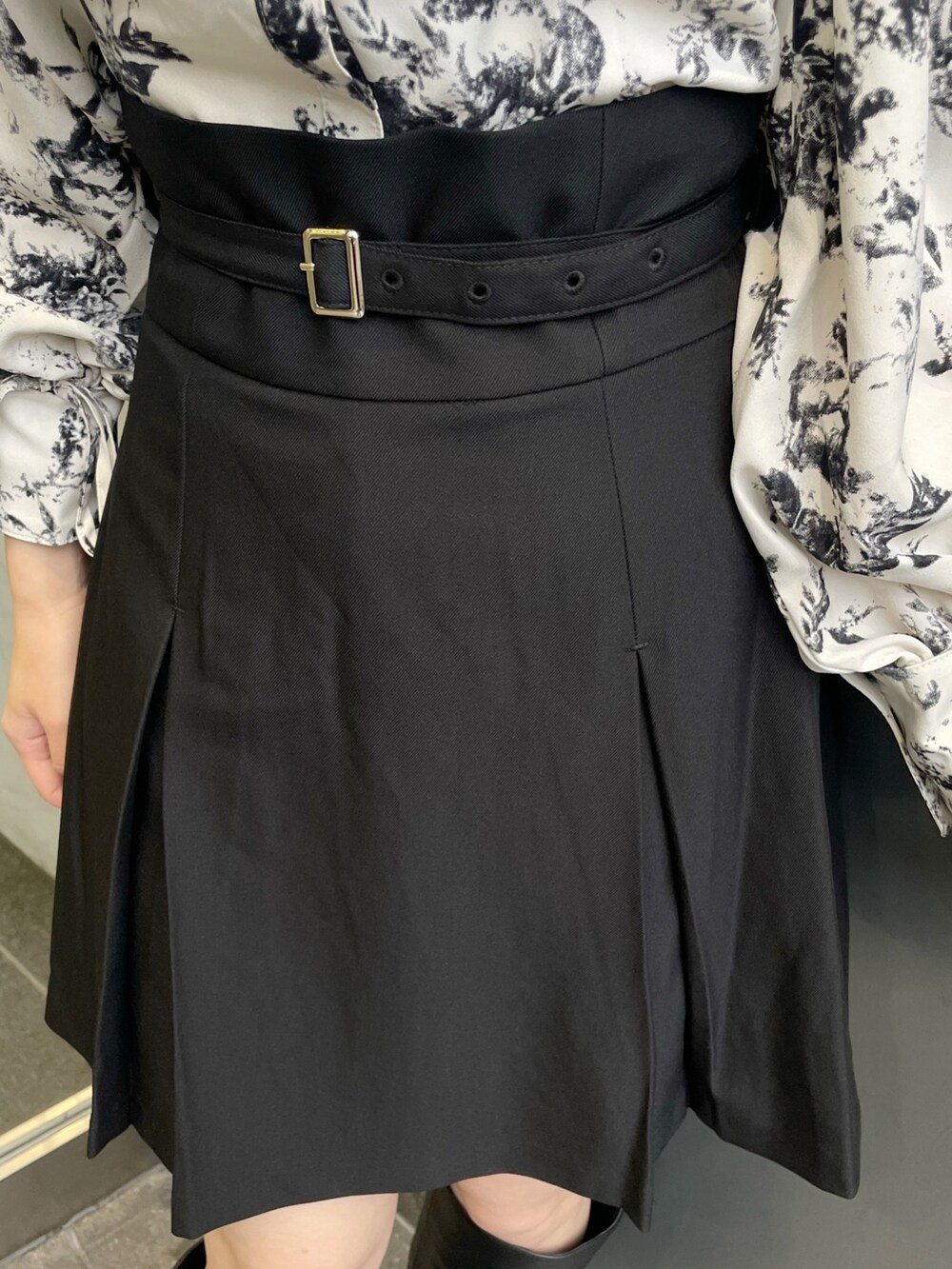 ホワイト系のシャツ/ブラウス、ブラック系のスカート、ブラック系のブーツを着用したレディースの冬コーディネートの8枚目の写真