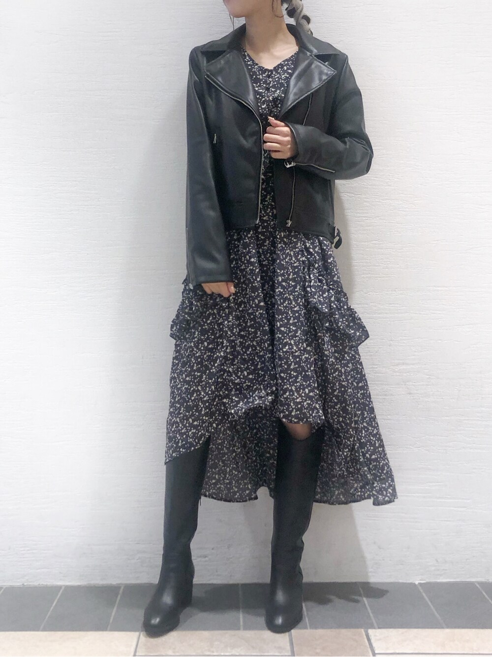 ブラック系のライダースジャケット、ブルー系のワンピース、ブラック系のブーツを着用したレディースの秋コーディネートの2枚目の写真