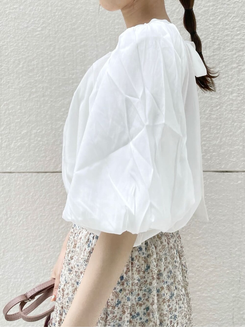 ブラウン系のハンドバッグ、ブラウン系のサンダル、ホワイト系のシャツ/ブラウスを着用したレディースの夏コーディネートの7枚目の写真