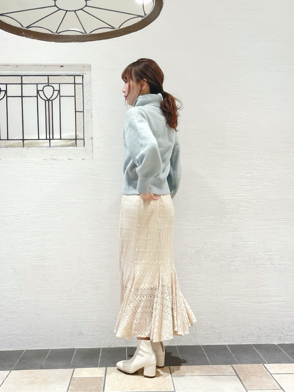 ホワイト系のスカート、ホワイト系のブーツ、ブルー系のニット/セーターを着用したレディースの冬コーディネートの4枚目の写真