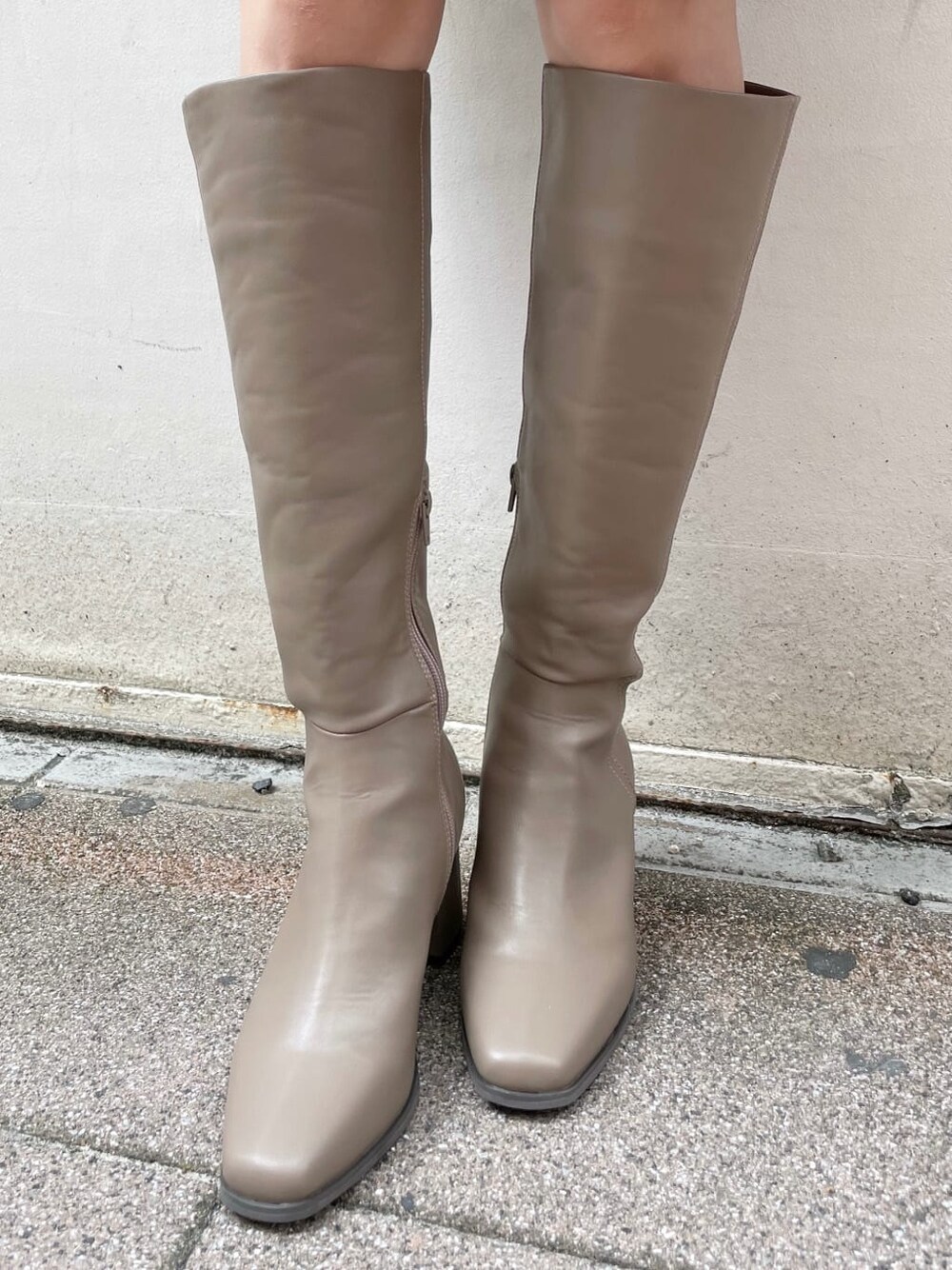 ブラウン系のスカート、ベージュ系のブーツ、ホワイト系のニット/セーターを着用したレディースの秋コーディネートの10枚目の写真