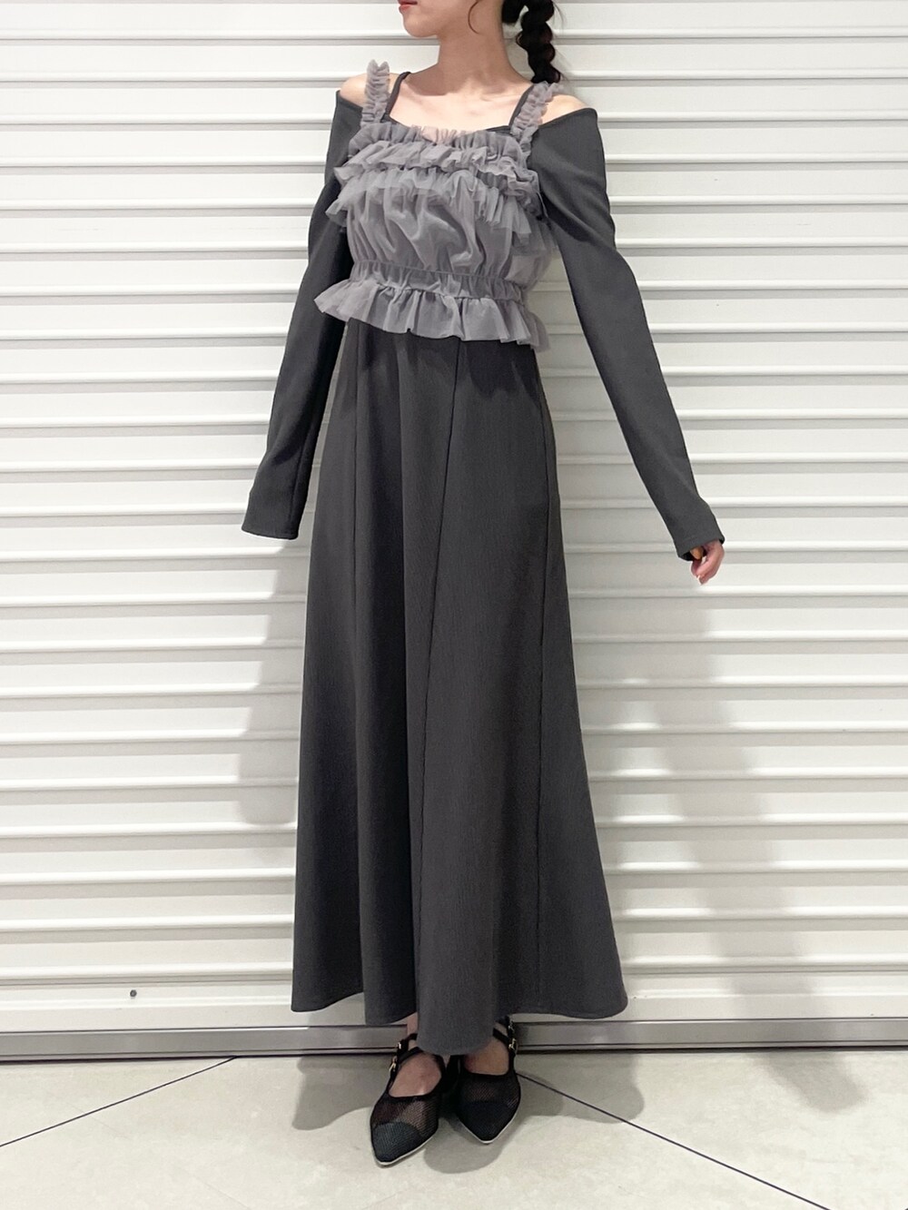 グレー系のワンピース、ブラック系のパンプスを着用したレディースの春コーディネートの2枚目の写真