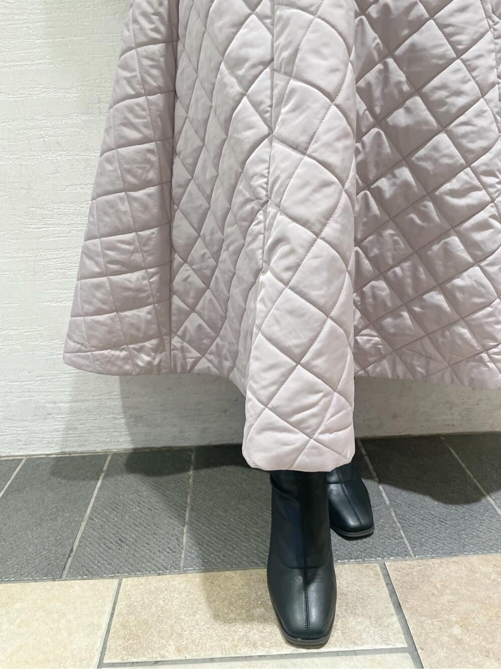 ピンク系のスカート、ブラック系のブーツ、ベージュ系のニット/セーターを着用したレディースの秋コーディネートの10枚目の写真