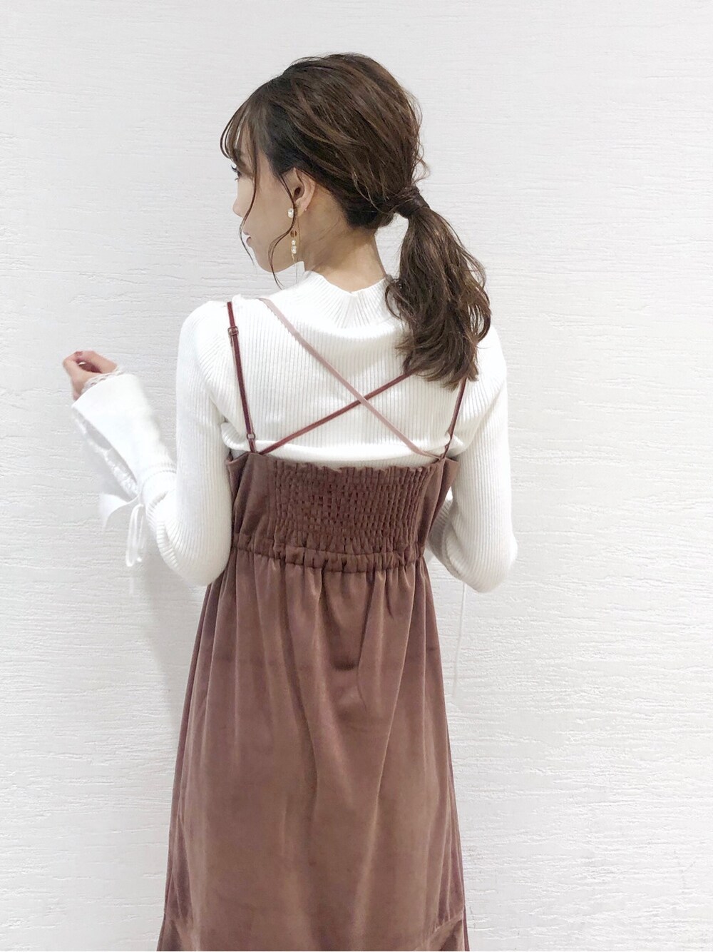 ホワイト系のニット/セーター、ピンク系のワンピース、ブラウン系のブーツを着用したレディースの秋コーディネートの5枚目の写真