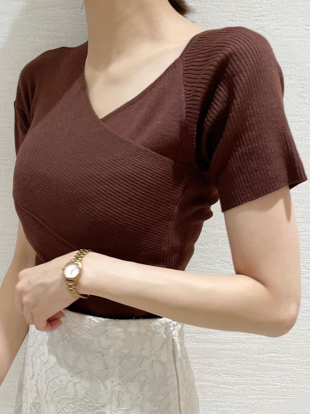 ホワイト系のスカート、ピンク系のダウンジャケット/コート、ブラウン系のニット/セーターを着用したレディースの夏コーディネートの9枚目の写真