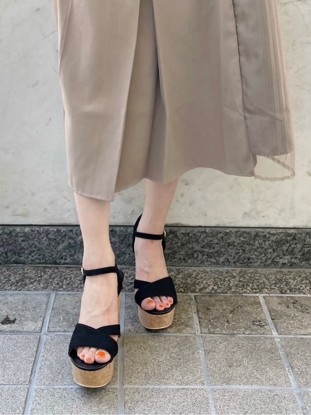 ブラック系のサンダル、ブラック系のTシャツ/カットソー、ベージュ系のスカートを着用したレディースの夏コーディネートの10枚目の写真