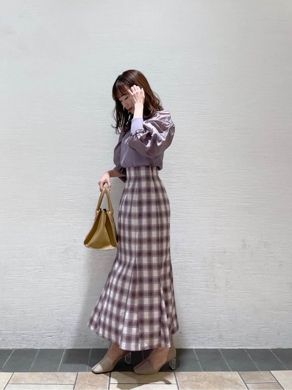 パープル系のスカート、ベージュ系のブーツ、パープル系のニット/セーターを着用したレディースの冬コーディネートの2枚目の写真