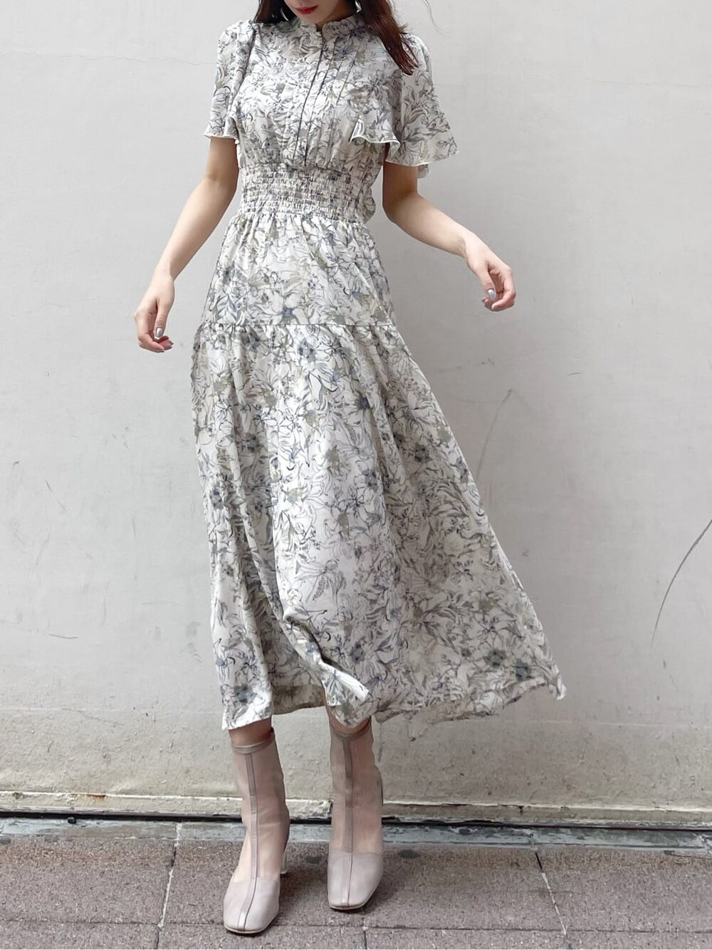 ベージュ系のトレンチコート、ホワイト系のワンピース、ベージュ系のブーツを着用したレディースの春コーディネートの5枚目の写真