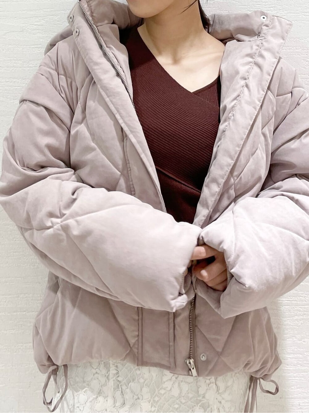 ホワイト系のスカート、ピンク系のダウンジャケット/コート、ブラウン系のニット/セーターを着用したレディースの夏コーディネートの3枚目の写真