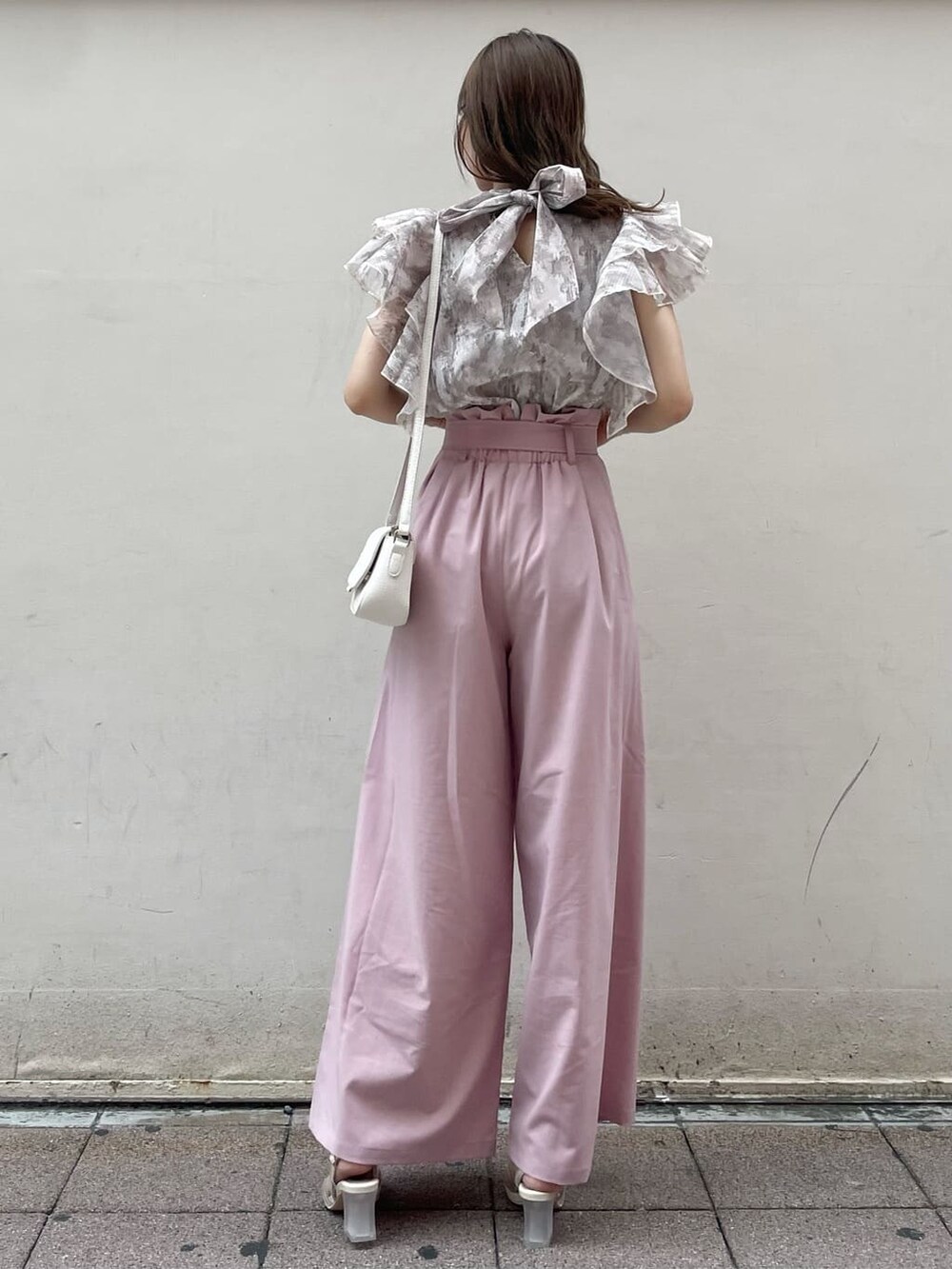 パープル系のサンダル、ホワイト系のショルダーバッグ、ベージュ系のシャツ/ブラウスを着用したレディースの夏コーディネートの3枚目の写真