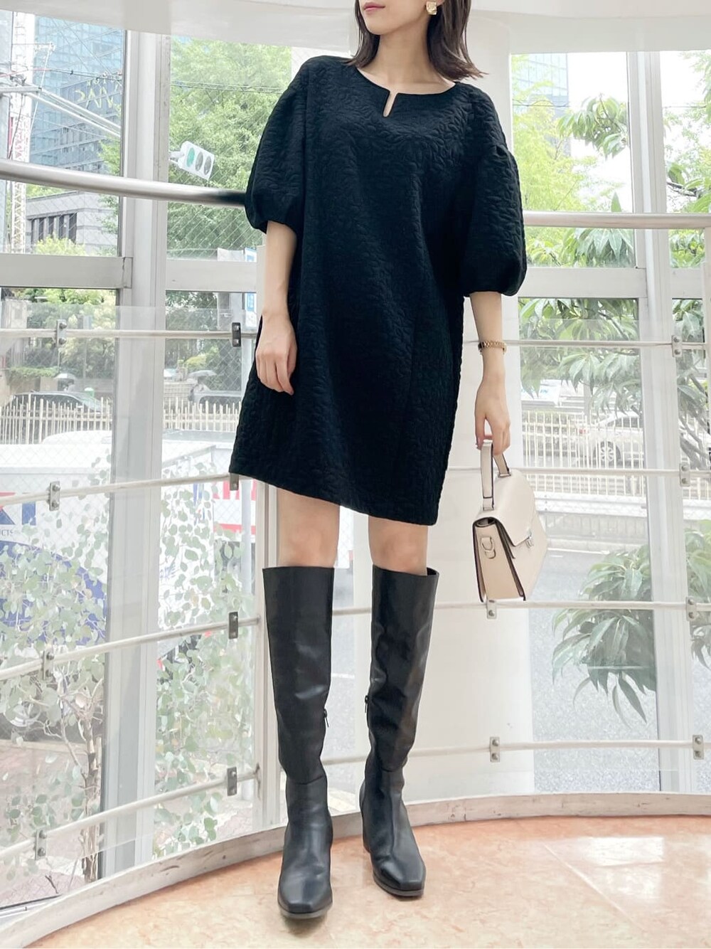 ブラック系のチュニック、ホワイト系のその他アウター、ブラック系のブーツを着用したレディースの夏コーディネートの7枚目の写真