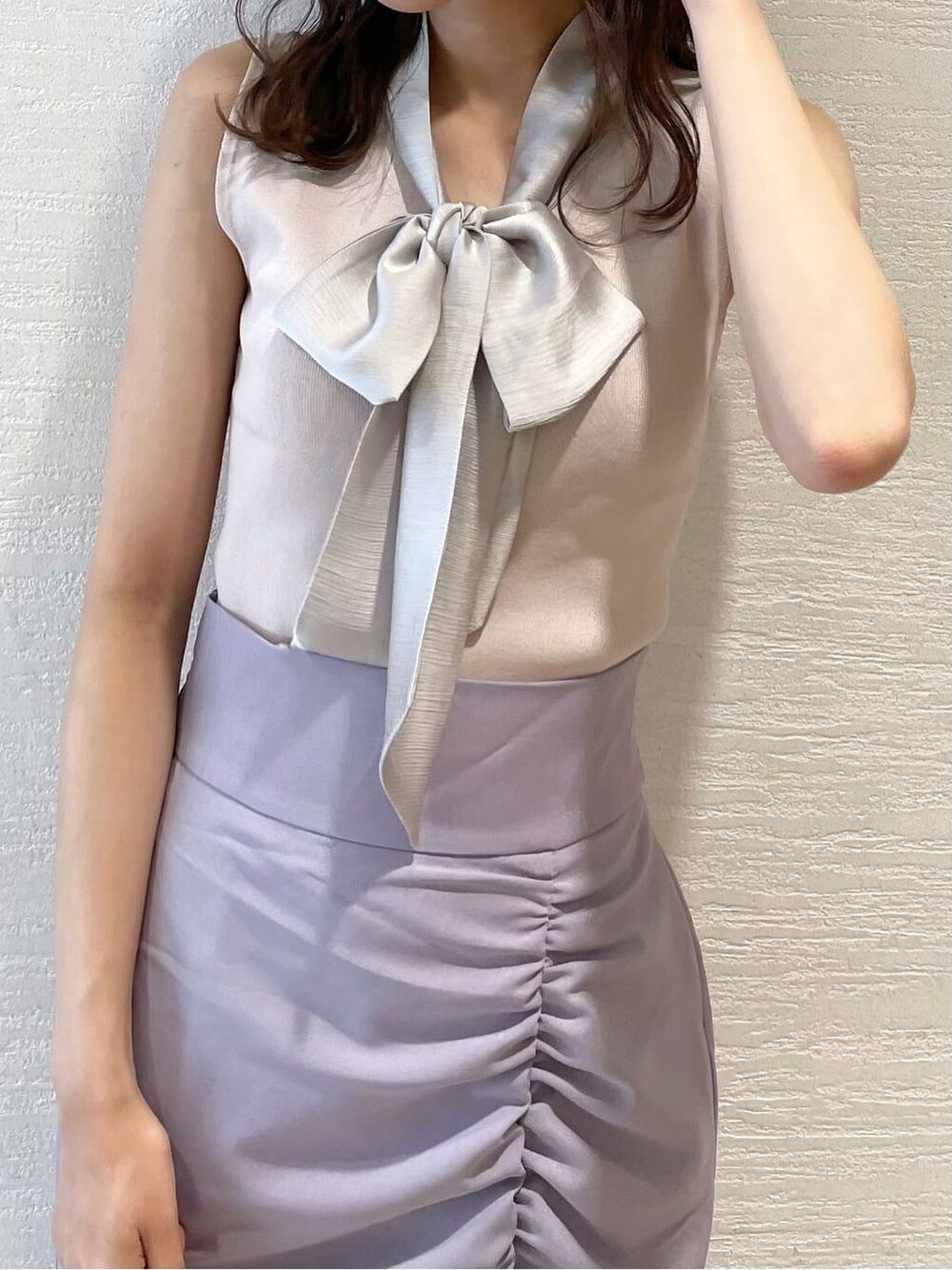 ホワイト系のハンドバッグ、ホワイト系のサンダル、グレー系のニット/セーターを着用したレディースの夏コーディネートの4枚目の写真