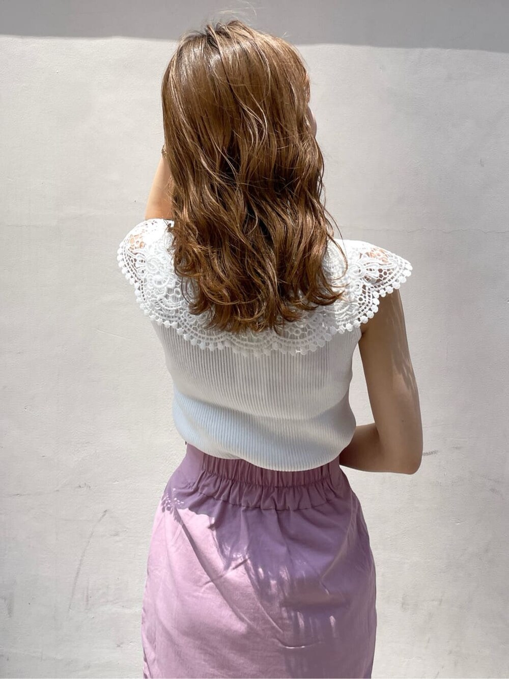 ブラック系のハンドバッグ、ピンク系のスカート、パープル系のサンダルを着用したレディースの夏コーディネートの7枚目の写真