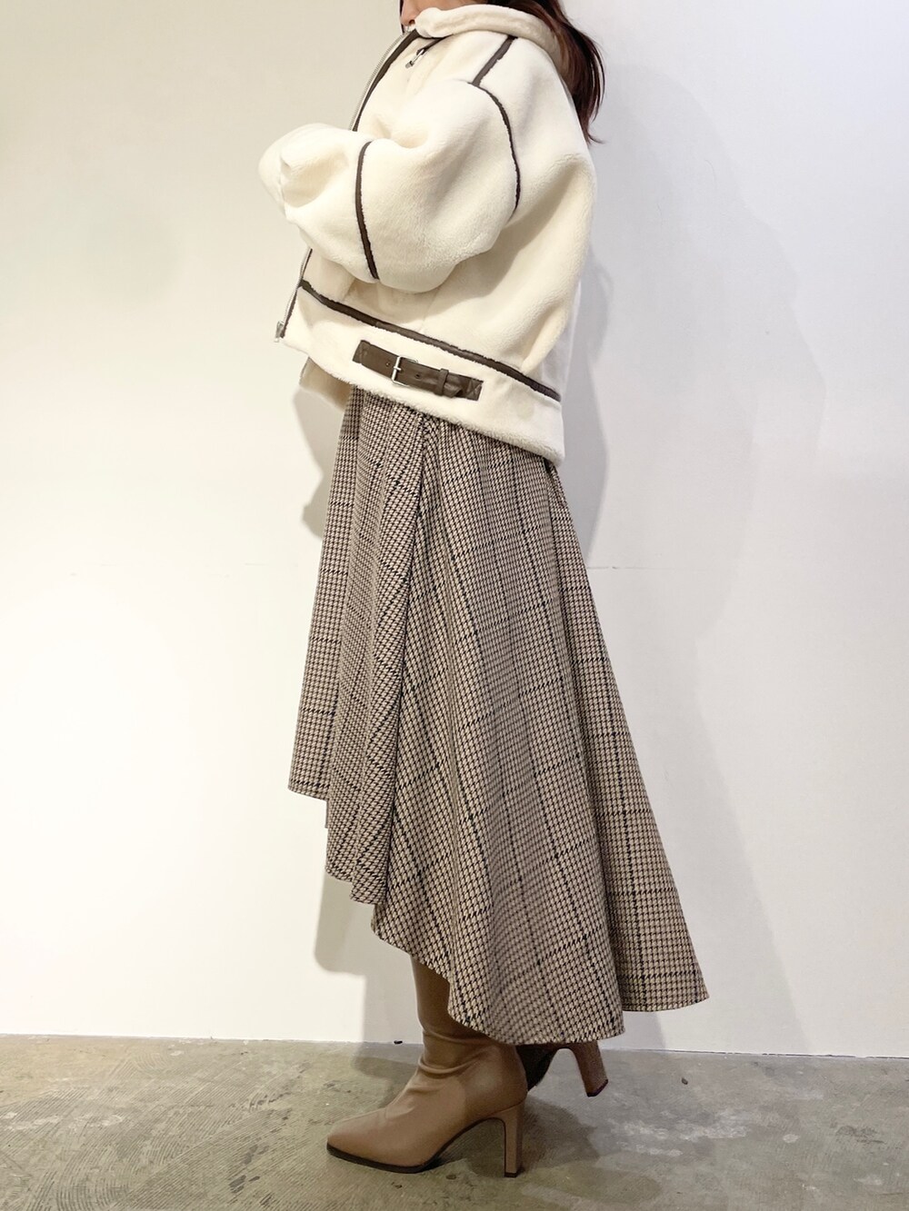 ブラウン系のワンピース、ベージュ系のブーツ、ホワイト系のブルゾンを着用したレディースの秋コーディネートの4枚目の写真