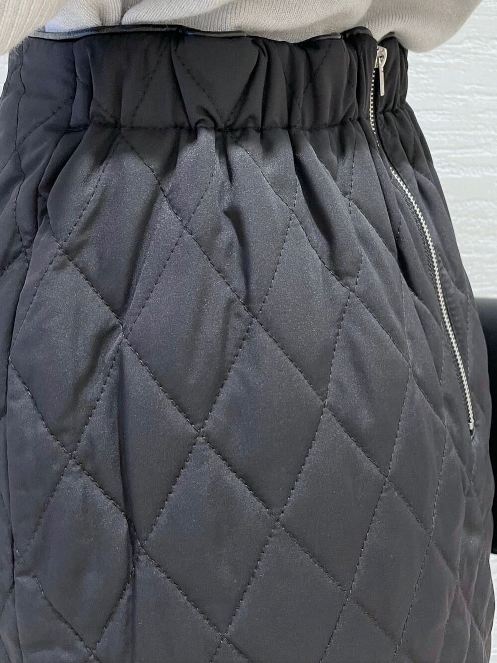 ブラック系のスカート、ブラック系のショルダーバッグ、グレー系のニット/セーターを着用したレディースの秋コーディネートの9枚目の写真