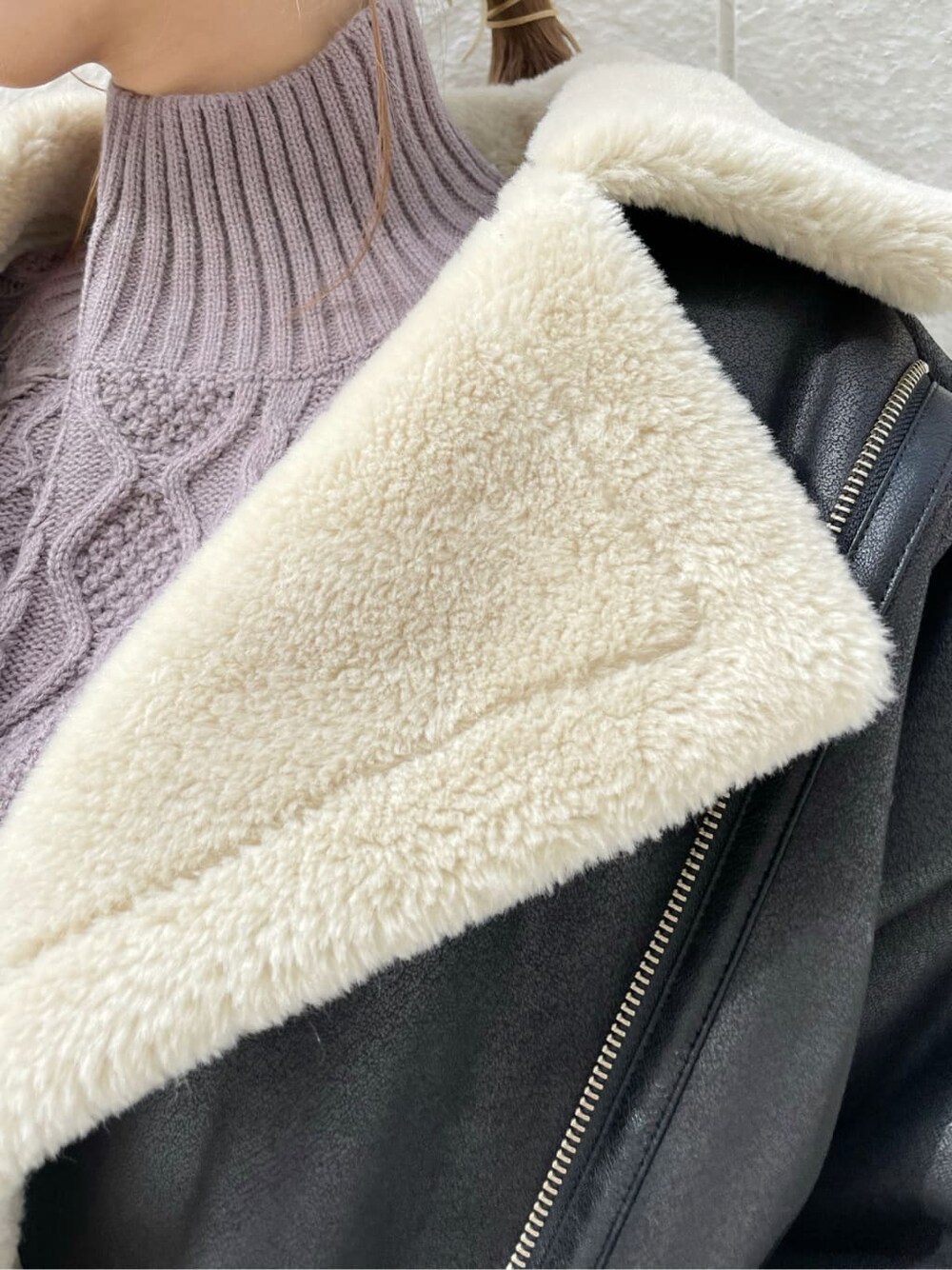 ブラック系のブルゾン、ベージュ系のスカート、ブラック系のブーツを着用したレディースの秋コーディネートの9枚目の写真