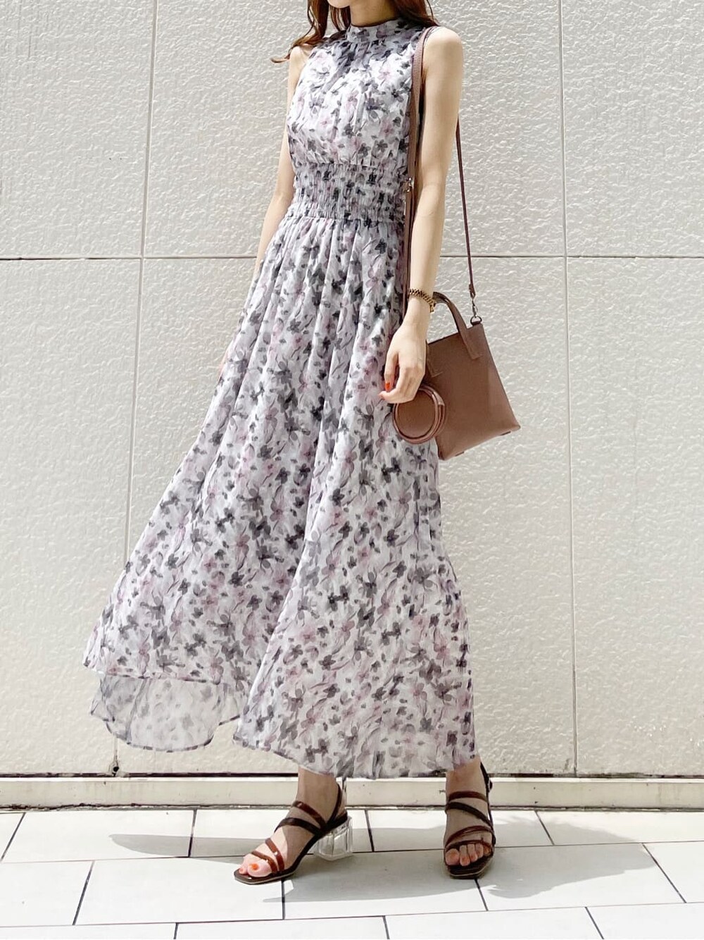 ブラウン系のハンドバッグ、ブラウン系のサンダル、ピンク系のワンピースを着用したレディースの夏コーディネートの2枚目の写真